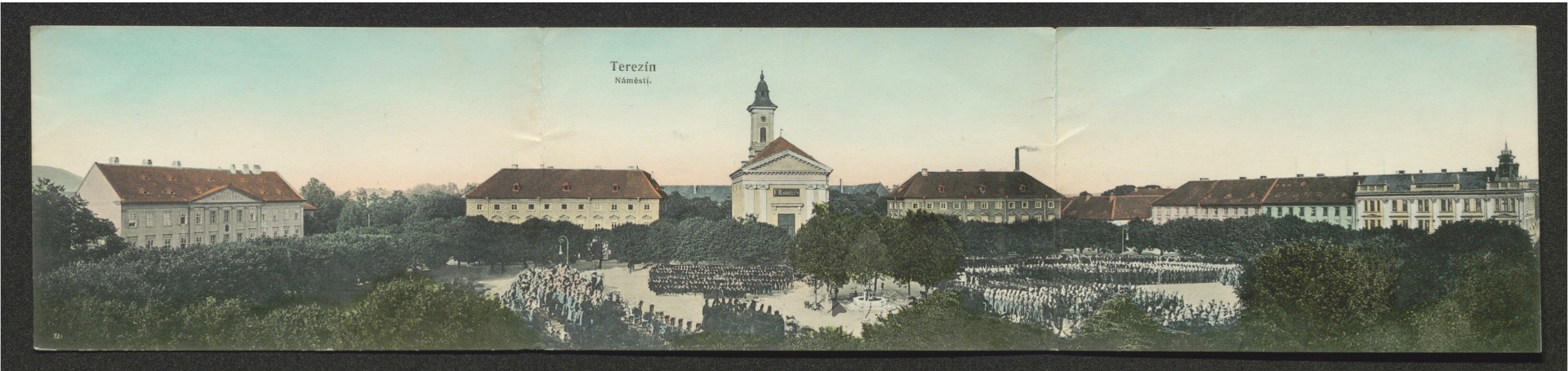Terezín — náměstí s kostelem a nastoupenou posádkou (dvoudílná panoramatická pohlednice)